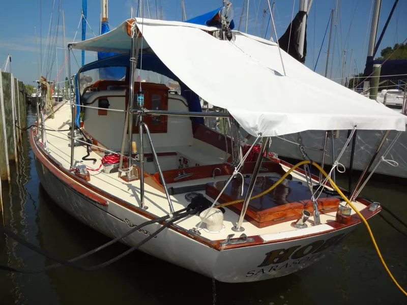 Slide: The Image of 1966 Cheoy Lee 36 Offshore Flying Buffalo yacht docked, featuring a white canopy and wooden deck. - 4