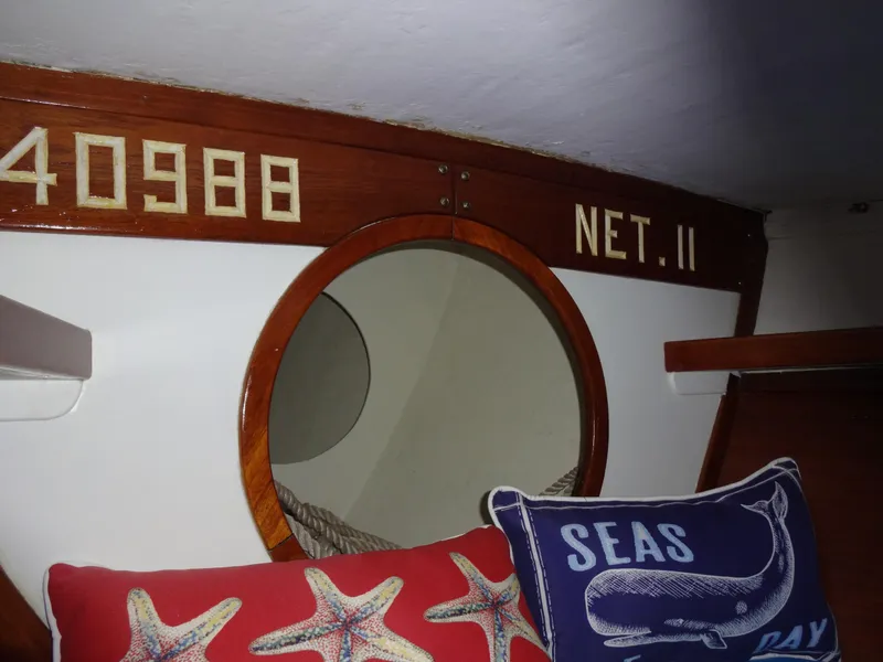 Slide: The Image of Interior of 1966 Cheoy Lee 36 Offshore, featuring nautical-themed pillows and wooden decor. - 42