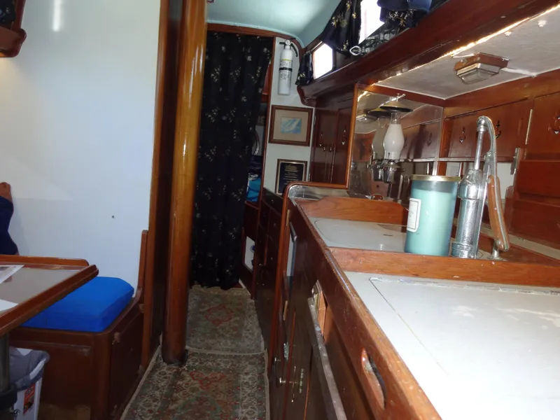 Slide: The Image of Interior of 1966 Cheoy Lee 36 Offshore Flying Buffalo, featuring wooden cabinetry and nautical decor. - 48