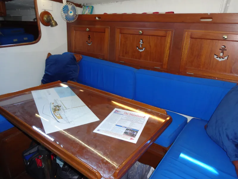 Slide: The Image of Interior of 1966 Cheoy Lee 36 Offshore, featuring blue seating and wooden cabinetry. - 49