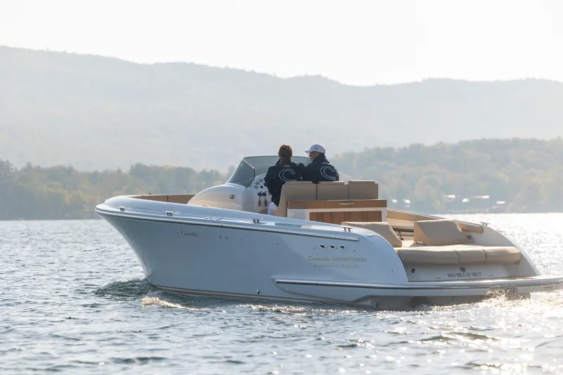 Slide: The Image of 2022 Comitti ISOLA 33 Sport SD luxury boat cruising on a serene lake with scenic mountain backdrop. - 17