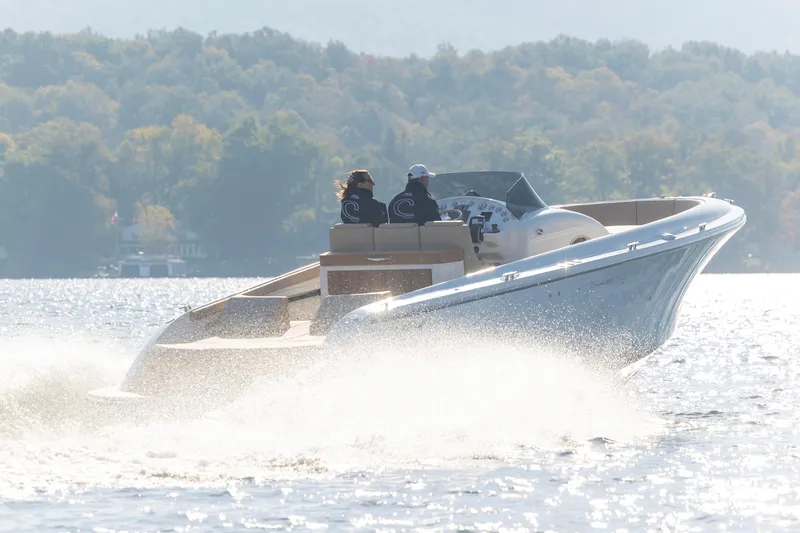 Slide: The Image of 2022 Comitti ISOLA 33 Sport SD speeding on a lake with forested hills in the background. - 19