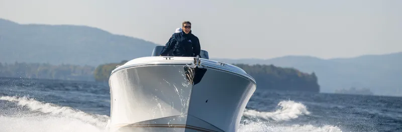 Slide: The Image of 2022 Comitti ISOLA 33 Sport SD cruising on a lake with mountains in the background. - 32