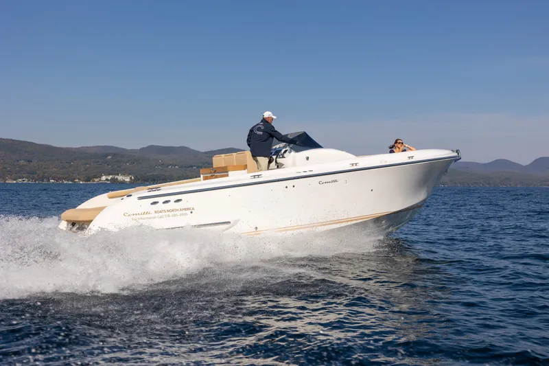 Slide: The Image of 2022 Comitti ISOLA 33 Sport SD cruising on a lake with mountains in the background. - 34