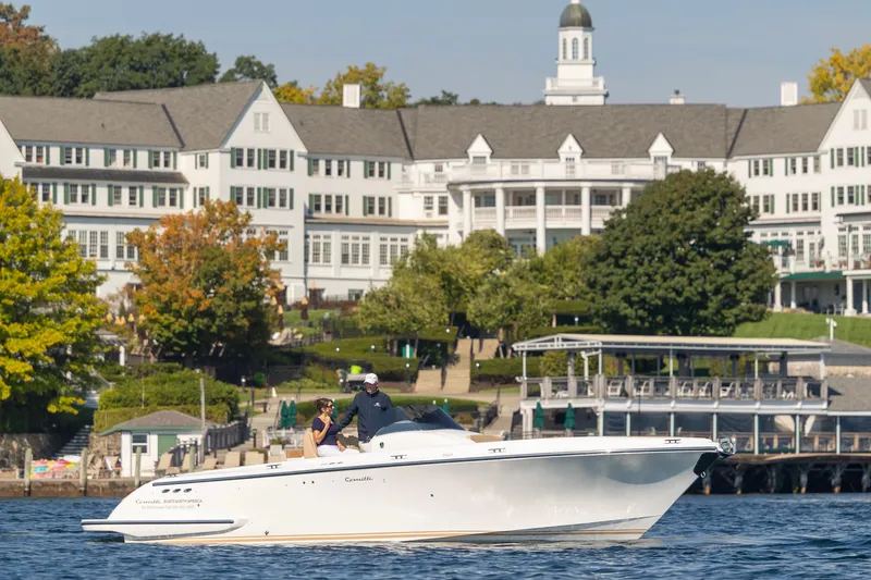 Slide: The Image of 2022 Comitti ISOLA 33 Sport SD boat cruising near a grand lakeside building. - 41