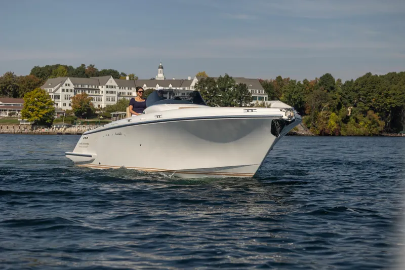 Slide: The Image of 2022 Comitti ISOLA 33 Sport SD cruising on a scenic lake near shoreline buildings. - 44