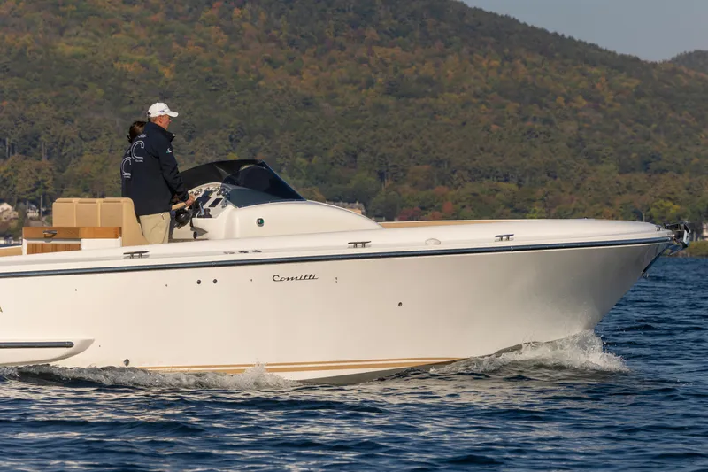 Slide: The Image of 2022 Comitti ISOLA 33 Sport SD cruising on a lake with scenic mountain backdrop. - 7