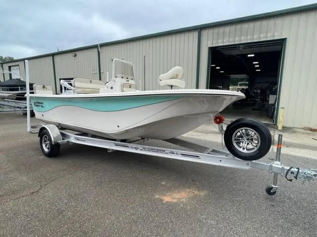 The Image of 2024 Carolina Skiff 19LS boat on a trailer outside a warehouse. - 0