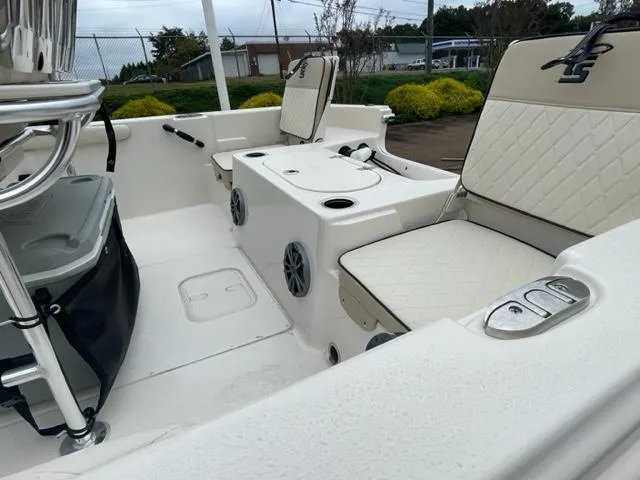 Slide: The Image of 2024 Carolina Skiff 19LS boat interior with white cushioned seating and storage compartments. - 7