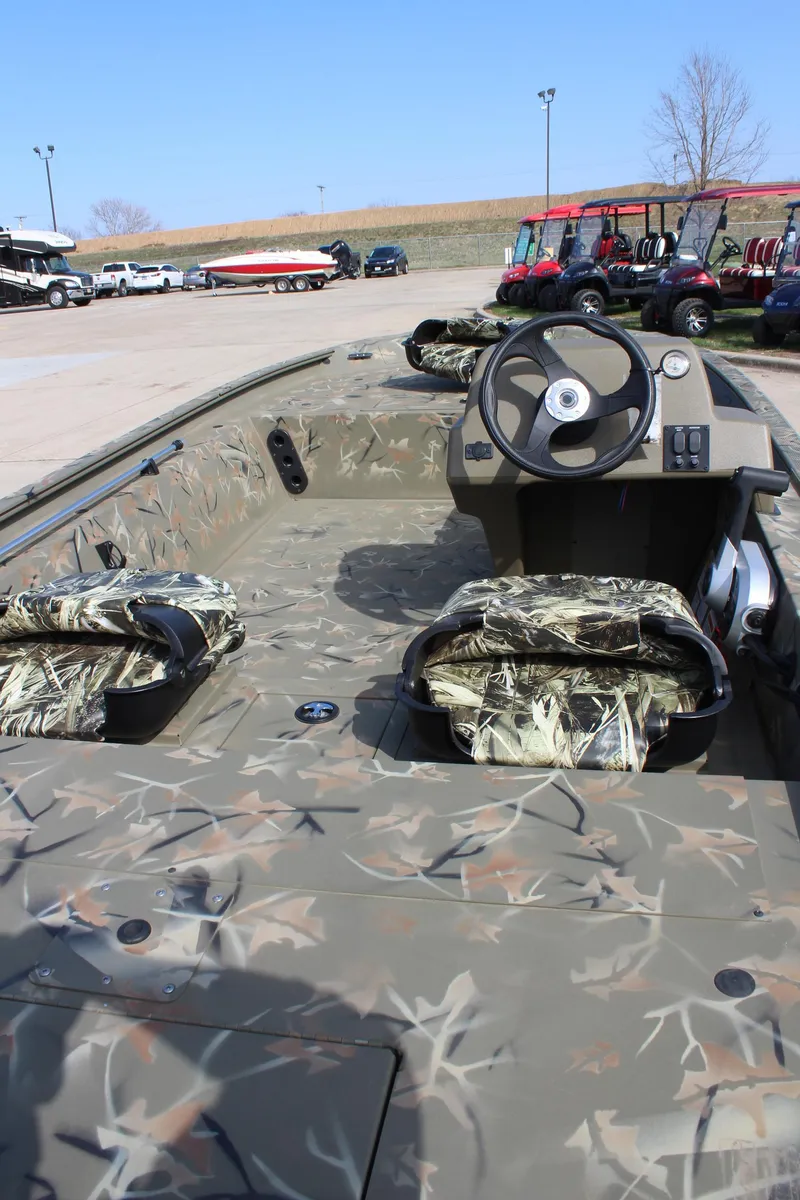 Slide: The Image of 2024 Tracker Grizzly 1754 SC camo boat interior with steering console. - 3