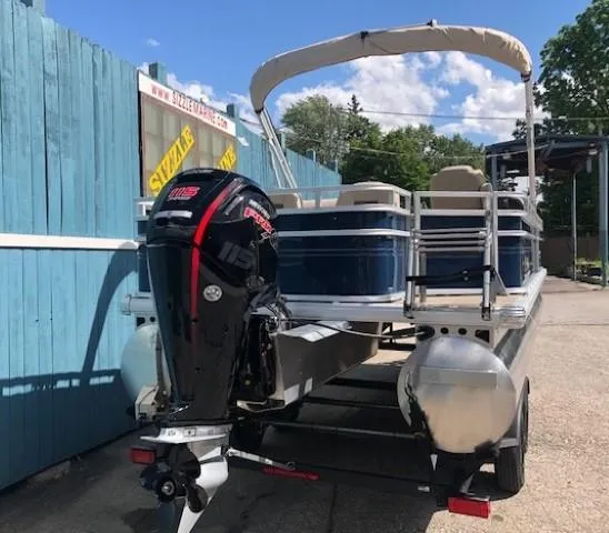 Slide: The Image of 2024 Sun Tracker Fishin' Barge 22 DLX pontoon boat with outboard motor on trailer. - 3