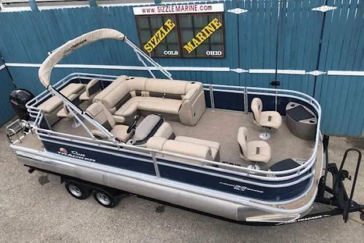 Slide: The Image of 2024 Sun Tracker Fishin' Barge 22 DLX pontoon boat with beige seating and canopy. - 4