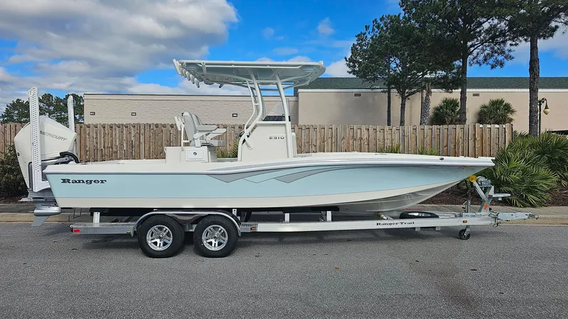 Slide: The Image of 2024 Ranger 2510 Bay boat on trailer, side view, outdoors. - 2