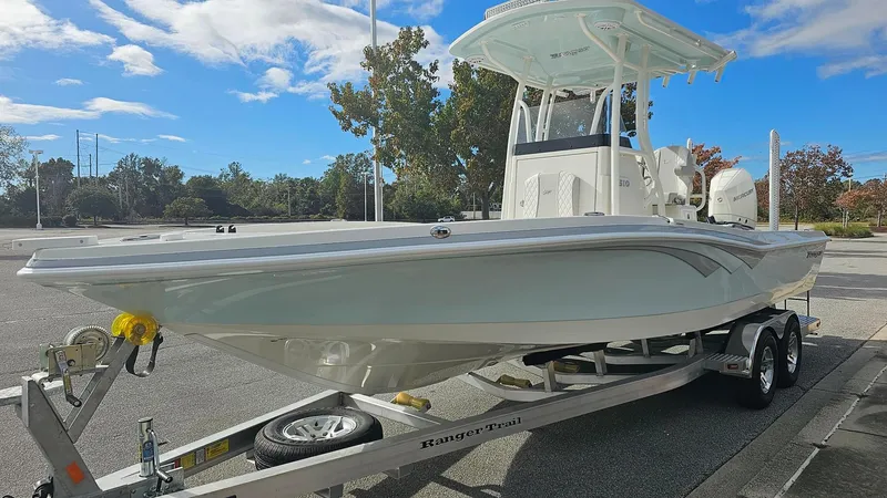 Slide: The Image of 2024 Ranger 2510 Bay boat on trailer in parking lot, clear sky background. - 3