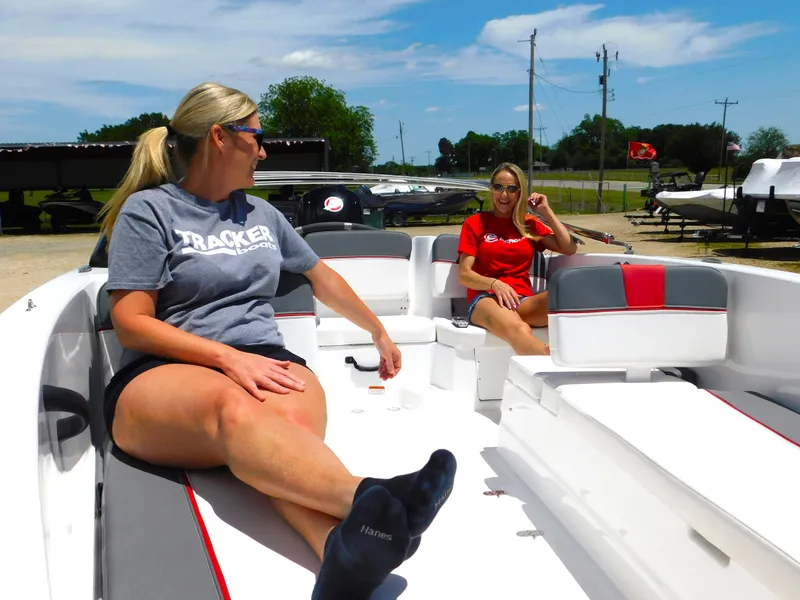 Slide: The Image of Two women relaxing on a 2024 Tahoe T18 boat in a sunny marina. - 10