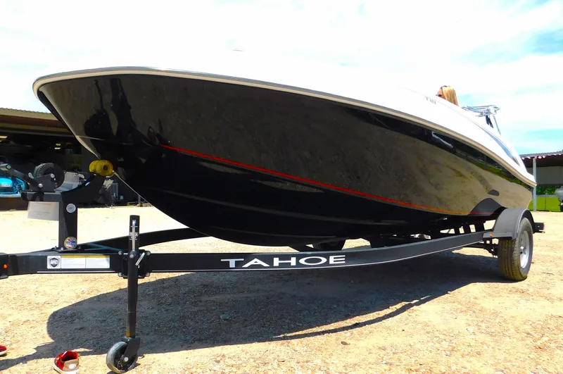 Slide: The Image of 2024 Tahoe T18 boat on trailer, black hull with red stripe, parked outdoors. - 12