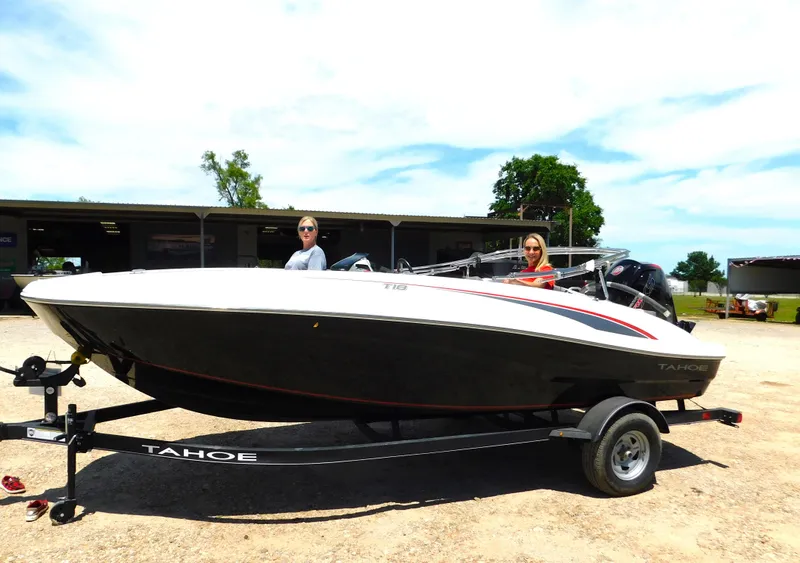Slide: The Image of 2024 Tahoe T18 boat on trailer with two people, outdoor setting. - 13