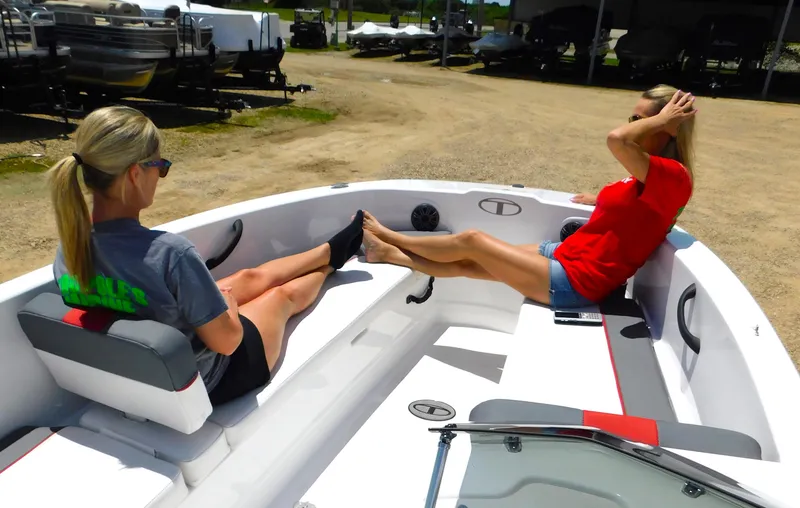 Slide: The Image of Two women relaxing on a 2024 Tahoe T18 boat at a marina. - 25