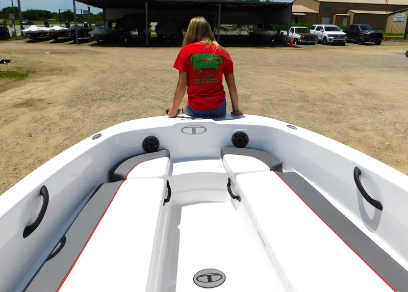 Slide: The Image of 2024 Tahoe T18 boat with a person sitting at the bow, parked on a lot. - 33