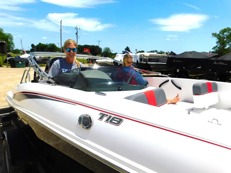 Slide: The Image of 2024 Tahoe T18 boat with two people onboard at a marina. - 6