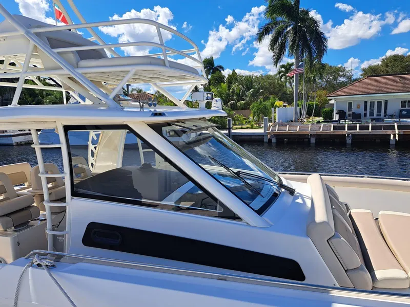 Slide: The Image of 2016 Boston Whaler 420 Outrage boat docked by a waterfront home. - 11