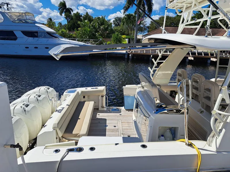 Slide: The Image of 2016 Boston Whaler 420 Outrage docked, showcasing spacious deck and seating area. - 13