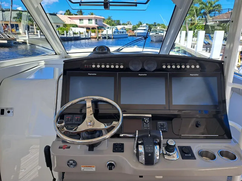 Slide: The Image of 2016 Boston Whaler 420 Outrage helm with advanced navigation system and waterfront view. - 16