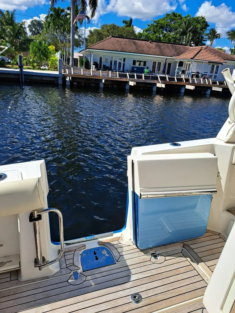 Slide: The Image of Boston Whaler 420 Outrage 2016 boat docked by waterfront home with wooden deck. - 19