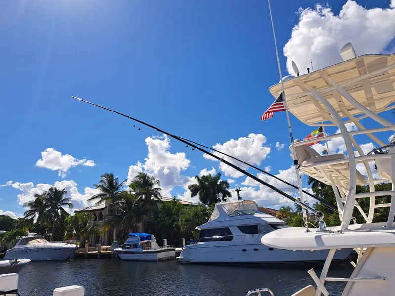 Slide: The Image of 2016 Boston Whaler 420 Outrage docked, with clear blue sky and palm trees in the background. - 22