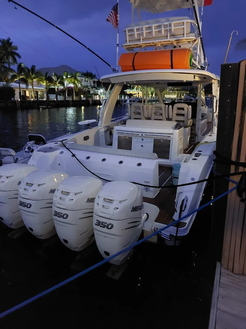 Slide: The Image of 2016 Boston Whaler 420 Outrage boat docked at night with four Mercury 350 engines. - 26