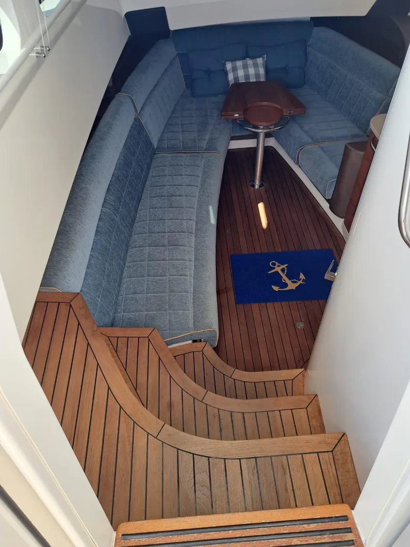Slide: The Image of Interior of 2016 Boston Whaler 420 Outrage with wooden flooring and blue seating. - 30