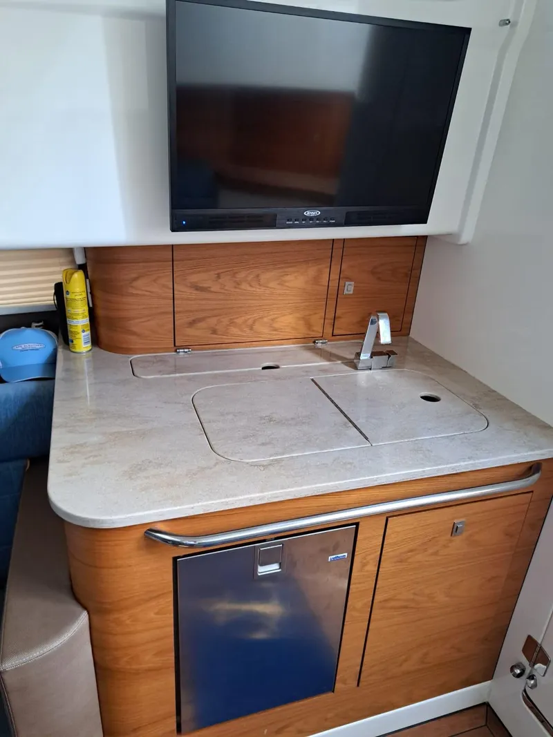 Slide: The Image of 2016 Boston Whaler 420 Outrage interior kitchenette with sink, countertop, and TV. - 31