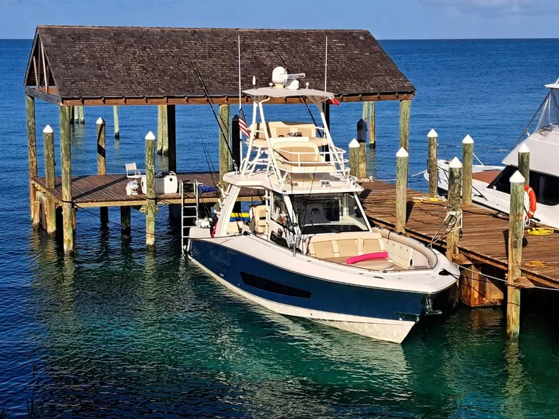 Slide: The Image of 2016 Boston Whaler 420 Outrage docked at a wooden pier on clear blue water. - 6