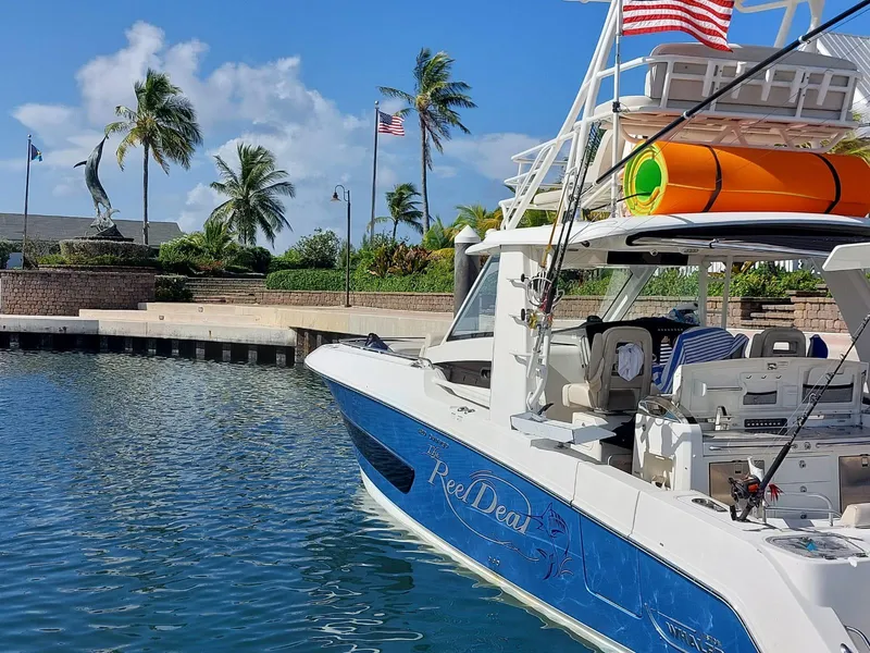 Slide: The Image of 2016 Boston Whaler 420 Outrage docked in a sunny marina with palm trees. - 7