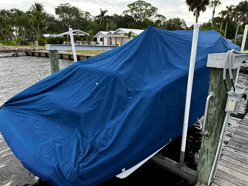 Slide: The Image of 2016 Crownline 285 SS boat covered with a blue tarp on a dock. - 12