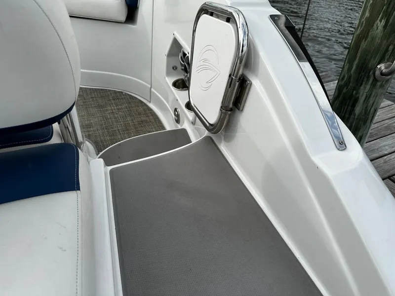 Slide: The Image of 2016 Crownline 285 SS boat interior, featuring white and gray seating near the dock. - 15