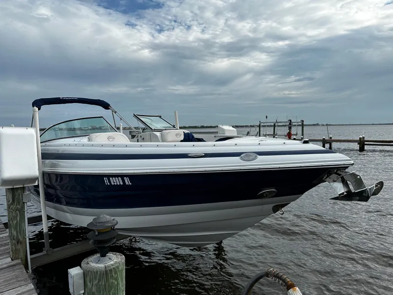Slide: The Image of 2016 Crownline 285 SS boat docked by the water on a cloudy day. - 2