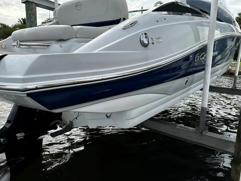 Slide: The Image of 2016 Crownline 285 SS boat on a lift, white and blue hull. - 4