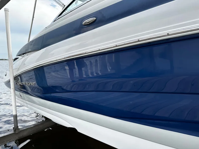 Slide: The Image of 2016 Crownline 285 SS boat with blue and white exterior on water. - 9