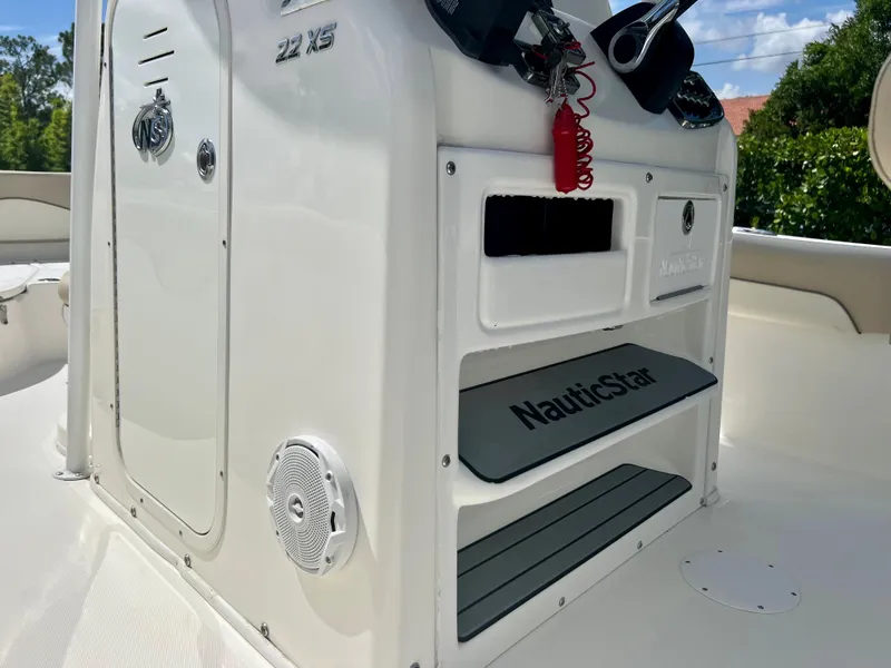 Slide: The Image of 2018 NauticStar 22 XS boat console with storage compartments and speaker. - 12