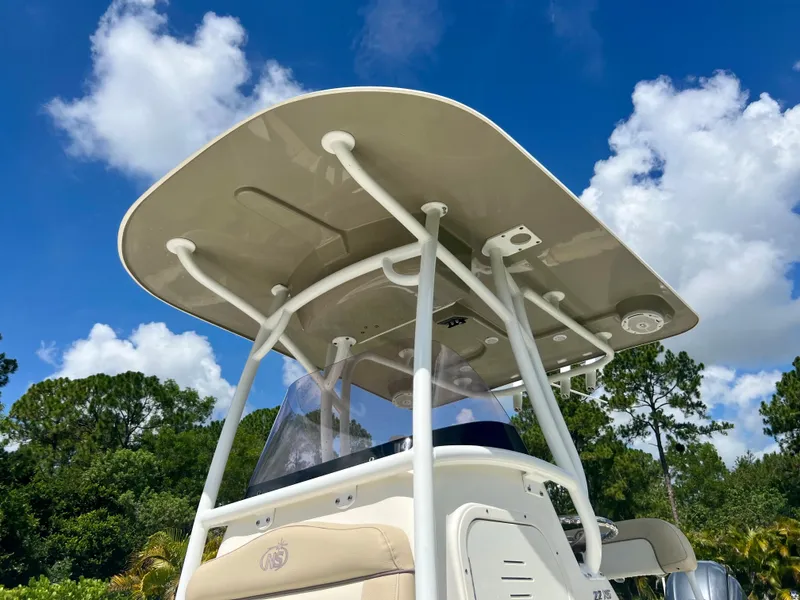 Slide: The Image of 2018 NauticStar 22 XS boat with T-top against blue sky and trees. - 14