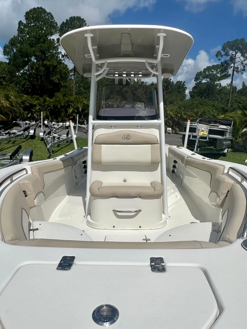 Slide: The Image of 2018 NauticStar 22 XS boat with seating and T-top in a marina. - 9