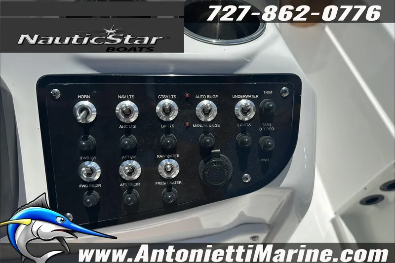 Slide: The Image of 2024 NauticStar 211 Hybrid boat control panel with various switches and logo. - 19