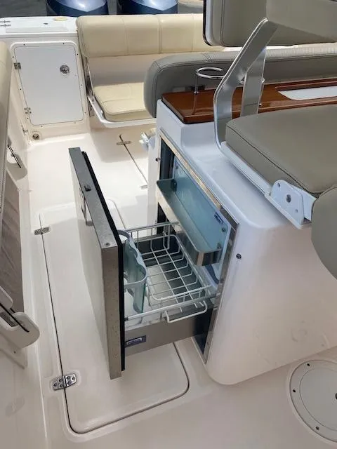 Slide: The Image of 2017 Pursuit S 280 Sport boat interior with open refrigerator drawer. - 12