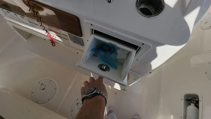 Slide: The Image of Person opening storage compartment on 2017 Pursuit S 280 Sport boat. - 20