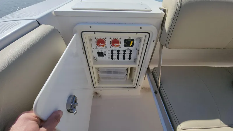 Slide: The Image of Control panel inside 2017 Pursuit S 280 Sport boat with open compartment door. - 21
