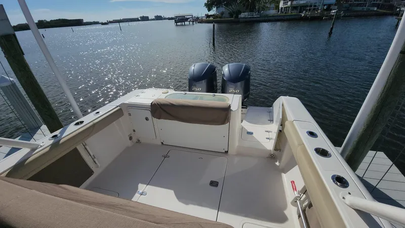 Slide: The Image of 2017 Pursuit S 280 Sport boat interior with twin engines, docked by a scenic waterfront. - 31