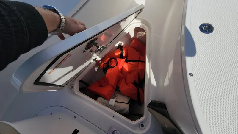 Slide: The Image of Storage compartment with life jackets on a 2017 Pursuit S 280 Sport boat. - 38