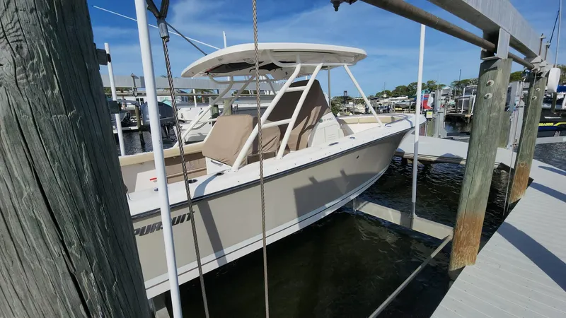 Slide: The Image of 2017 Pursuit S 280 Sport boat docked at marina under blue sky. - 39