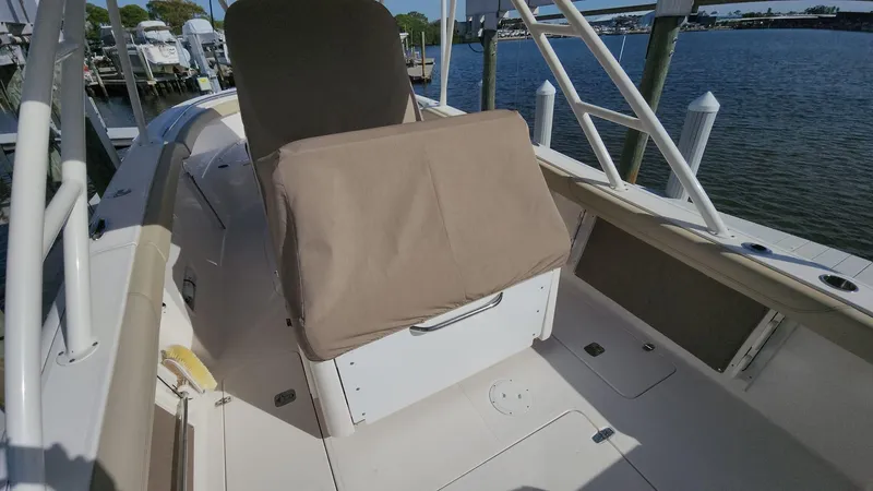 Slide: The Image of 2017 Pursuit S 280 Sport boat interior with covered seating, docked by the water. - 41